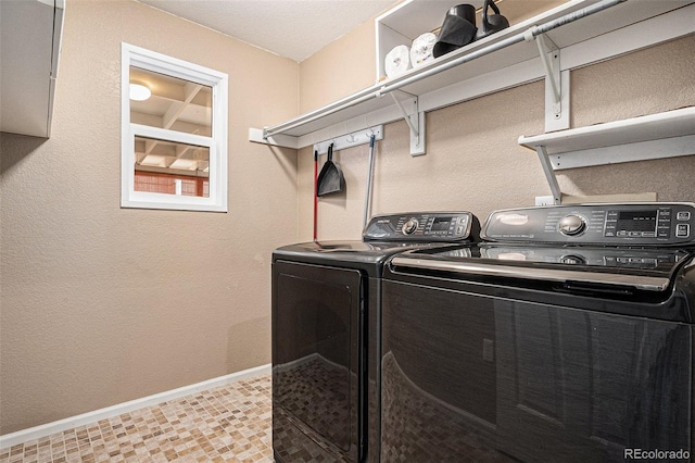 clothes washing area featuring laundry area, washing machine and dryer, and baseboards