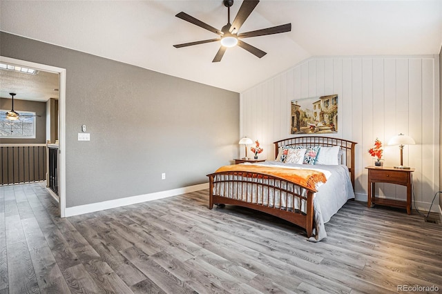 bedroom featuring a ceiling fan, lofted ceiling, baseboards, and wood finished floors