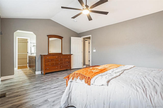 bedroom featuring visible vents, arched walkways, ceiling fan, wood finished floors, and vaulted ceiling