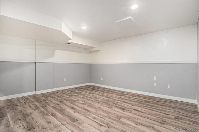 spare room featuring baseboards, wood finished floors, and recessed lighting