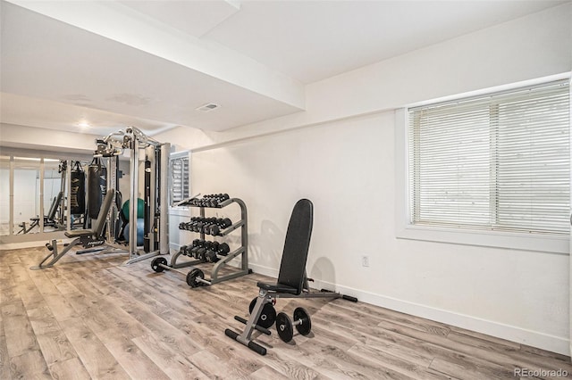 workout room with visible vents, baseboards, and wood finished floors