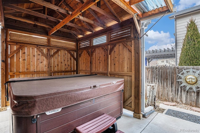 view of patio with fence and a hot tub