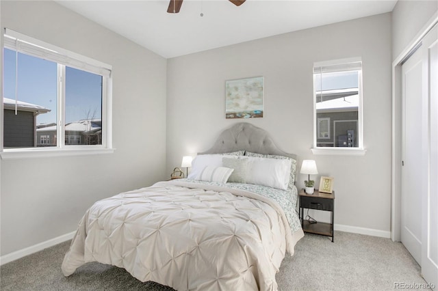 bedroom featuring light colored carpet, ceiling fan, and a closet