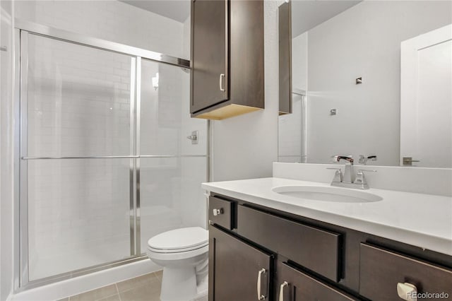 bathroom featuring tile patterned flooring, vanity, toilet, and an enclosed shower