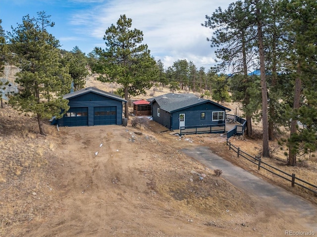 ranch-style home featuring a detached garage and an outbuilding