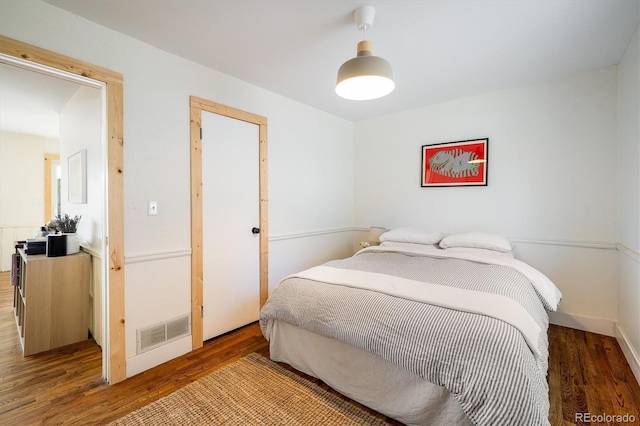 bedroom featuring visible vents and wood finished floors