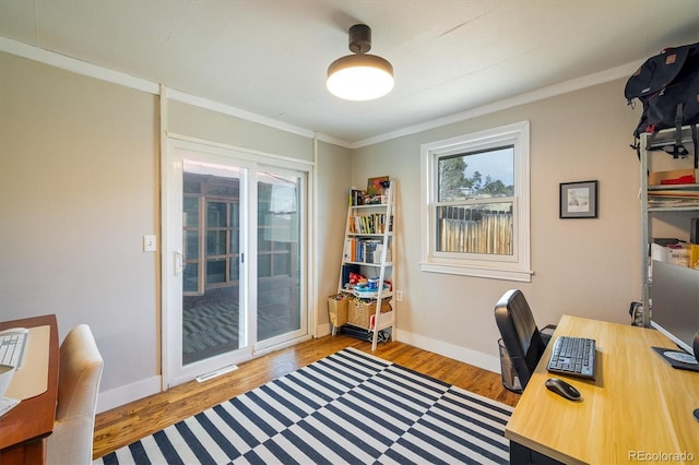 office space with ornamental molding, visible vents, baseboards, and wood finished floors