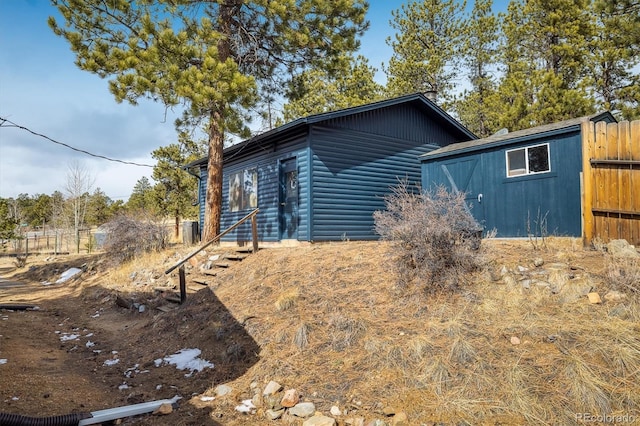 view of home's exterior featuring fence and faux log siding