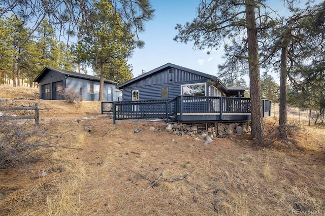 rear view of house with board and batten siding and a wooden deck