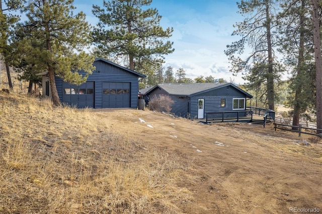 view of front of house with a detached garage and a wooden deck