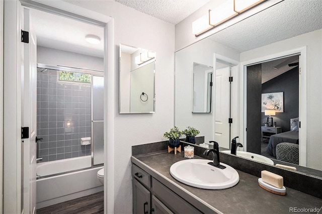 2882 W Long Cir Unit H, Littleton, CO 80120 - ensuite bathroom featuring a textured ceiling, vanity, shower / washtub combination, and wood finished floors