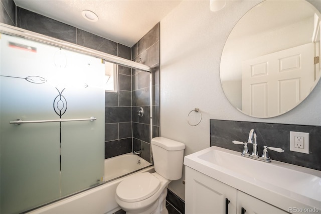 full bathroom with decorative backsplash, vanity, toilet, and bath / shower combo with glass door