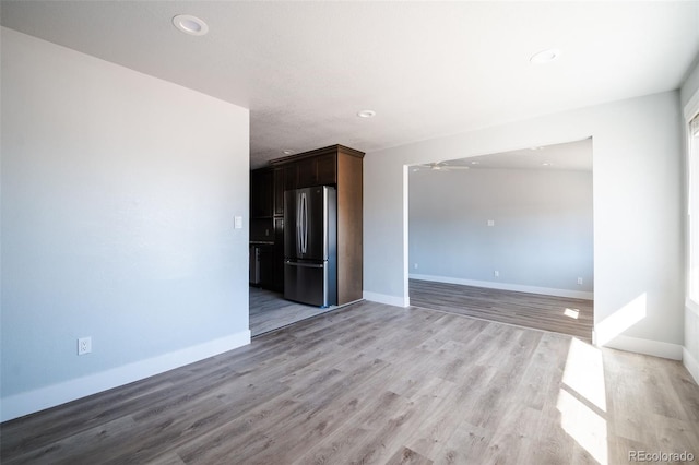 empty room featuring recessed lighting, light wood-type flooring, a ceiling fan, and baseboards