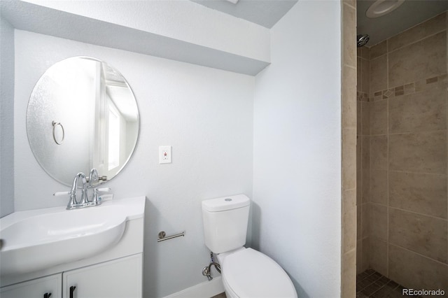 full bathroom with vanity, a tile shower, and toilet