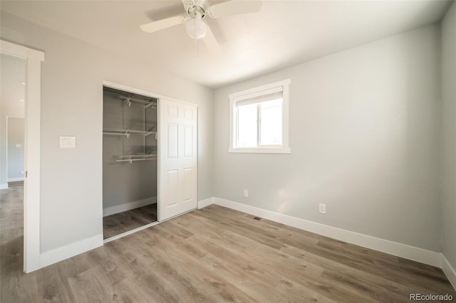 unfurnished bedroom featuring a ceiling fan, a closet, baseboards, and wood finished floors