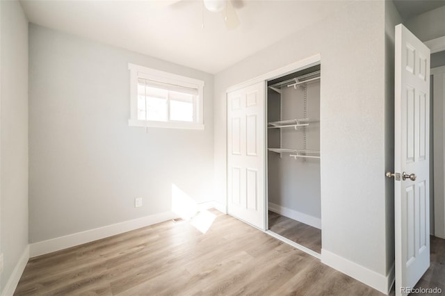 unfurnished bedroom featuring a closet, ceiling fan, baseboards, and wood finished floors