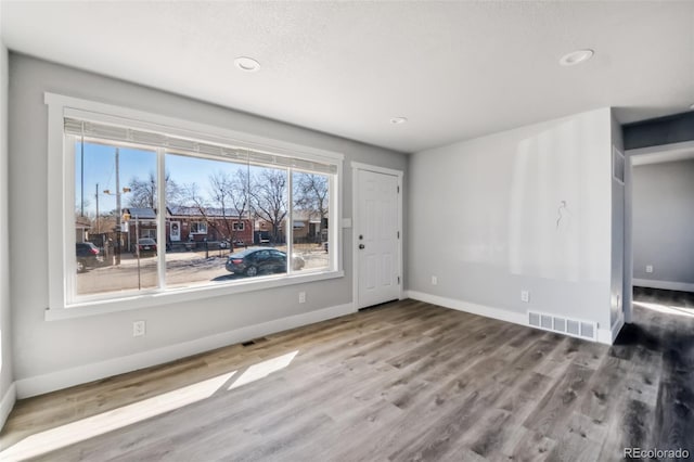 interior space with baseboards, visible vents, wood finished floors, and recessed lighting