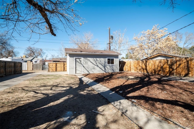 rear view of property featuring fence private yard and an outbuilding