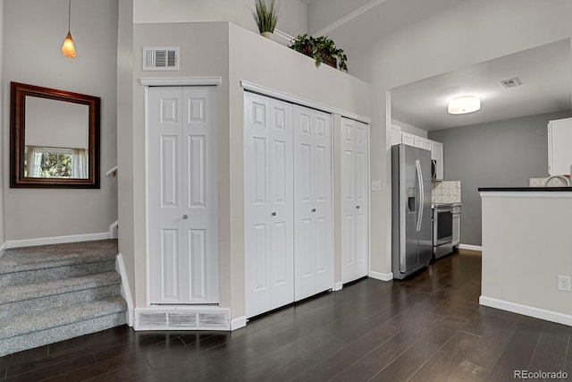 kitchen with white cabinets, stainless steel appliances, and dark hardwood / wood-style floors