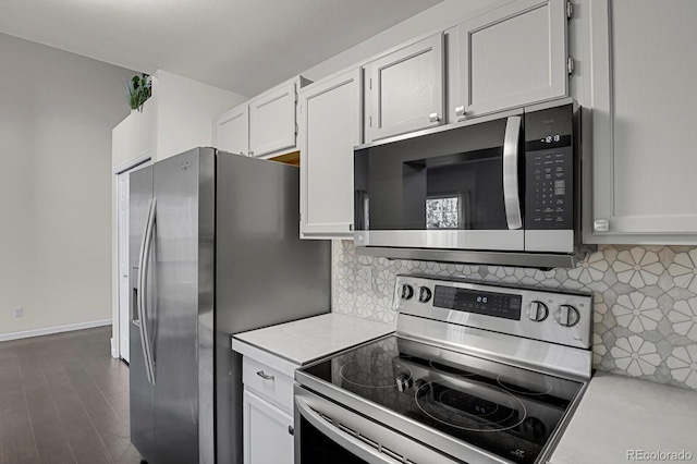 kitchen with white cabinets, decorative backsplash, and appliances with stainless steel finishes