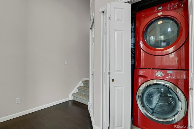 laundry area with dark hardwood / wood-style flooring and stacked washing maching and dryer