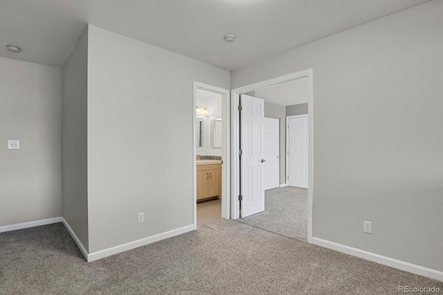 unfurnished bedroom with light carpet and ensuite bath