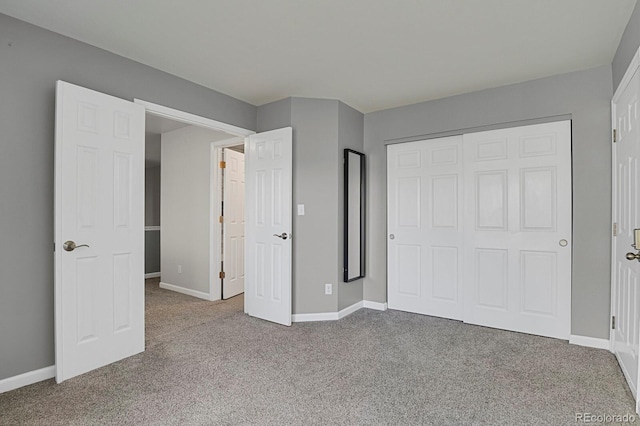 unfurnished bedroom featuring light colored carpet and a closet