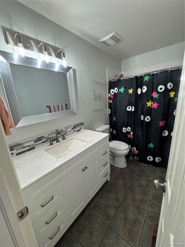 11549 Haskell Creek Rd, Larkspur, CO 80118 - full bath with toilet, vanity, a textured ceiling, tile patterned flooring, and a textured wall
