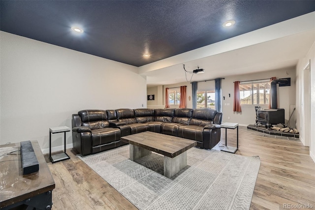 11549 Haskell Creek Rd, Larkspur, CO 80118 - living area with a wood stove, light wood-style flooring, baseboards, and recessed lighting