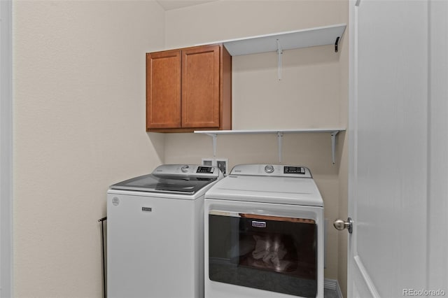 washroom with separate washer and dryer and cabinets