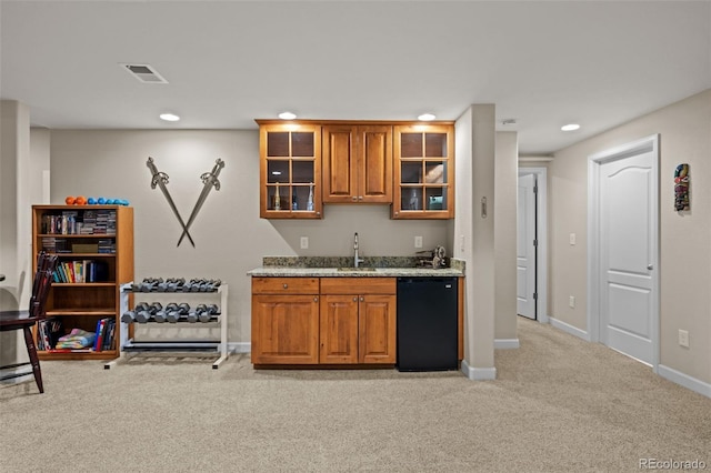 bar featuring light stone countertops, black dishwasher, sink, and light carpet