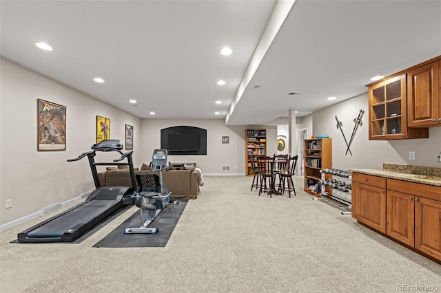 exercise area featuring light colored carpet and indoor wet bar