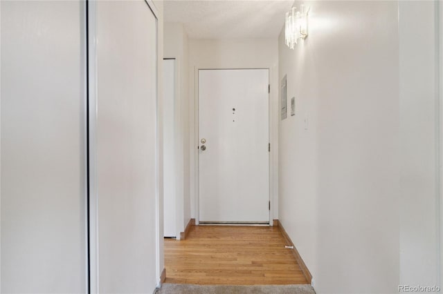 hallway with a textured ceiling and light hardwood / wood-style floors