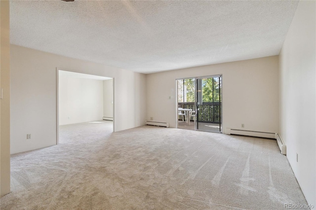 spare room with a baseboard heating unit, a textured ceiling, and light carpet