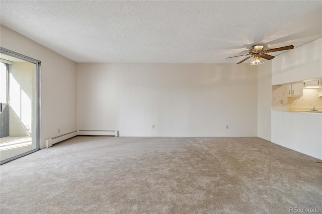 carpeted empty room featuring ceiling fan, a textured ceiling, and a baseboard heating unit