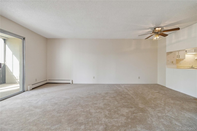 carpeted spare room with a ceiling fan, a textured ceiling, and a baseboard radiator