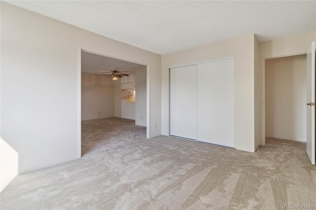 unfurnished bedroom featuring a closet, a textured ceiling, and carpet