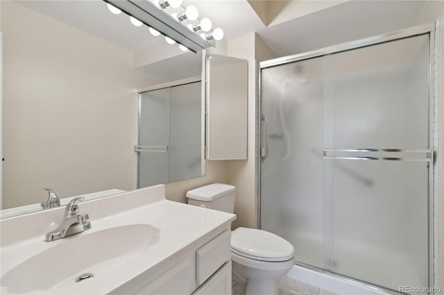 bathroom with tile patterned flooring, vanity, a shower with door, and toilet