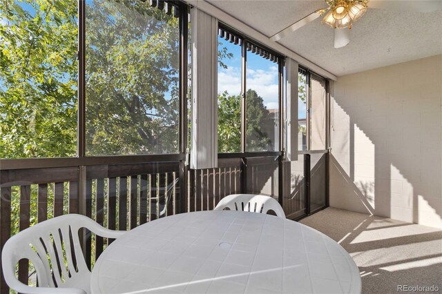 sunroom / solarium featuring outdoor dining space and ceiling fan