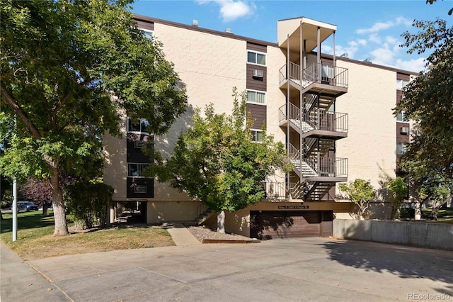 view of property with driveway, stairway, and a garage