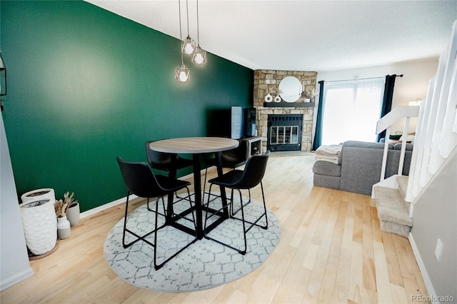 1699 S Trenton St Unit 69, Denver, CO 80231 - dining room featuring wood finished floors, a stone fireplace, and an accent wall