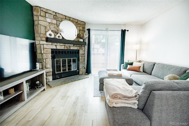1699 S Trenton St Unit 69, Denver, CO 80231 - living area featuring wood finished floors, a fireplace, and a textured ceiling
