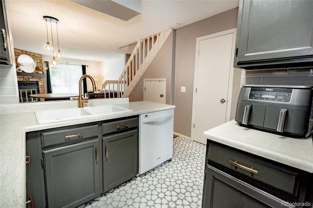 1699 S Trenton St Unit 69, Denver, CO 80231 - kitchen with white dishwasher, light flooring, a peninsula, light countertops, and a stone fireplace