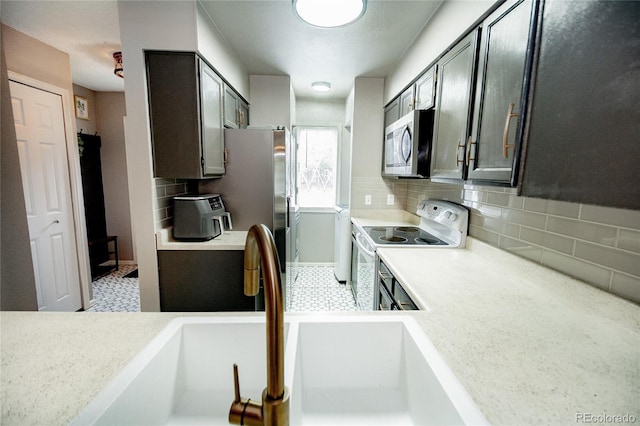1699 S Trenton St Unit 69, Denver, CO 80231 - kitchen featuring stainless steel appliances, light countertops, and backsplash