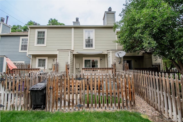 1699 S Trenton St Unit 69, Denver, CO 80231 - back of property featuring a chimney and a fenced backyard