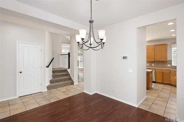 4488 Larksong Pl, Castle Rock, CO 80109 - unfurnished dining area featuring light wood-style floors, a chandelier, recessed lighting, and stairs