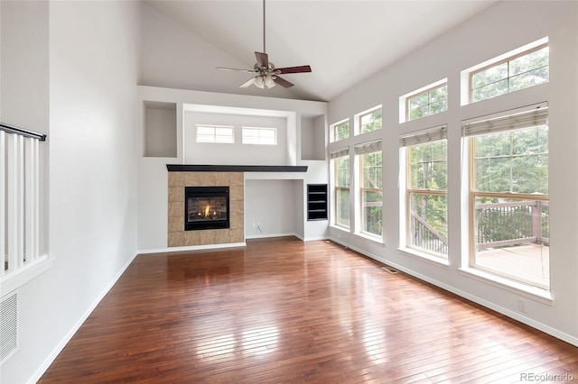 4488 Larksong Pl, Castle Rock, CO 80109 - unfurnished living room with high vaulted ceiling, wood-type flooring, a tiled fireplace, and a ceiling fan