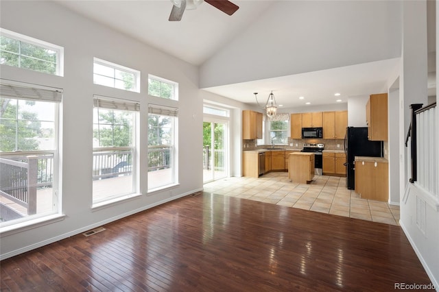 4488 Larksong Pl, Castle Rock, CO 80109 - unfurnished living room with light wood finished floors, healthy amount of natural light, high vaulted ceiling, a ceiling fan, and recessed lighting