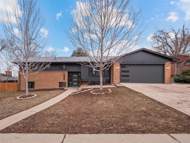 mid-century inspired home featuring concrete driveway, an attached garage, fence, and brick siding