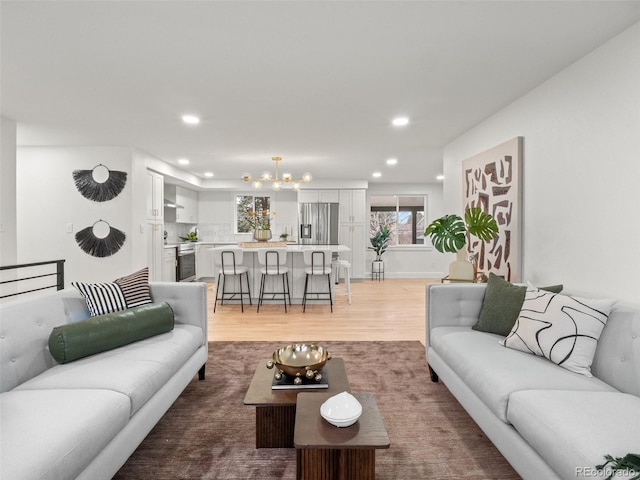 living room featuring recessed lighting, an inviting chandelier, and light wood finished floors